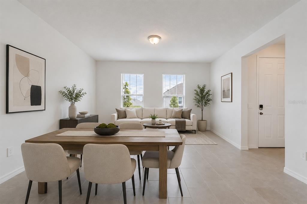 A dining area with a wooden table and chairs opens into a living room — 4512 HOMESTEAD TRAIL, ST CLOUD, FL