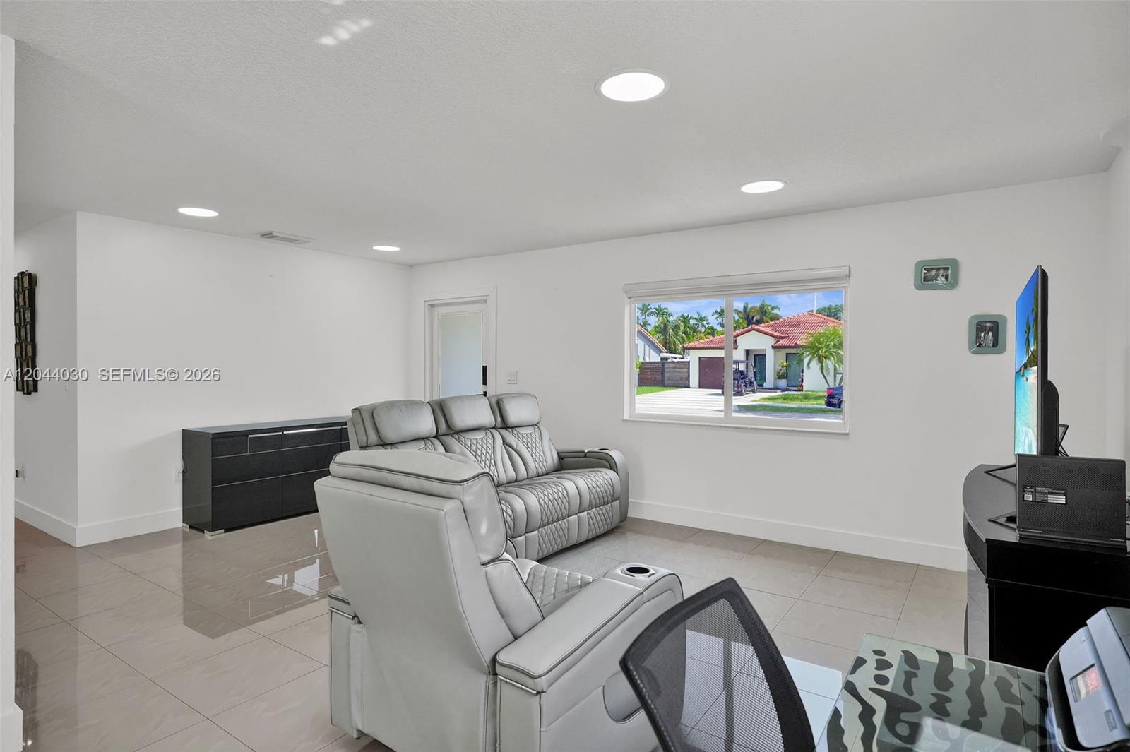 A living room features light gray tile floors, white walls, recessed lighting, and a gray sofa — 12551 SW 223 ST, Miami FL 33170, MIAMI, FL