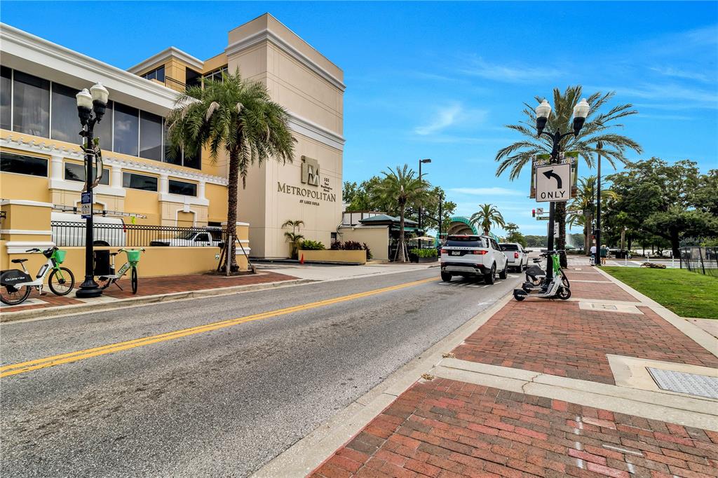 A street view shows the Metropolitan building exterior with palm trees, parked bicycles, and vehicles — 151 E WASHINGTON STREET UNIT 5B, ORLANDO, FL