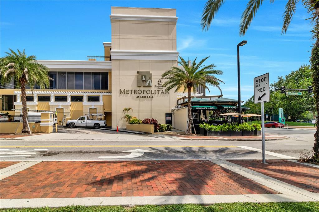 Exterior view of the Metropolitan at Lake Eola building with a restaurant and palm trees — 151 E WASHINGTON STREET UNIT 5B, ORLANDO, FL