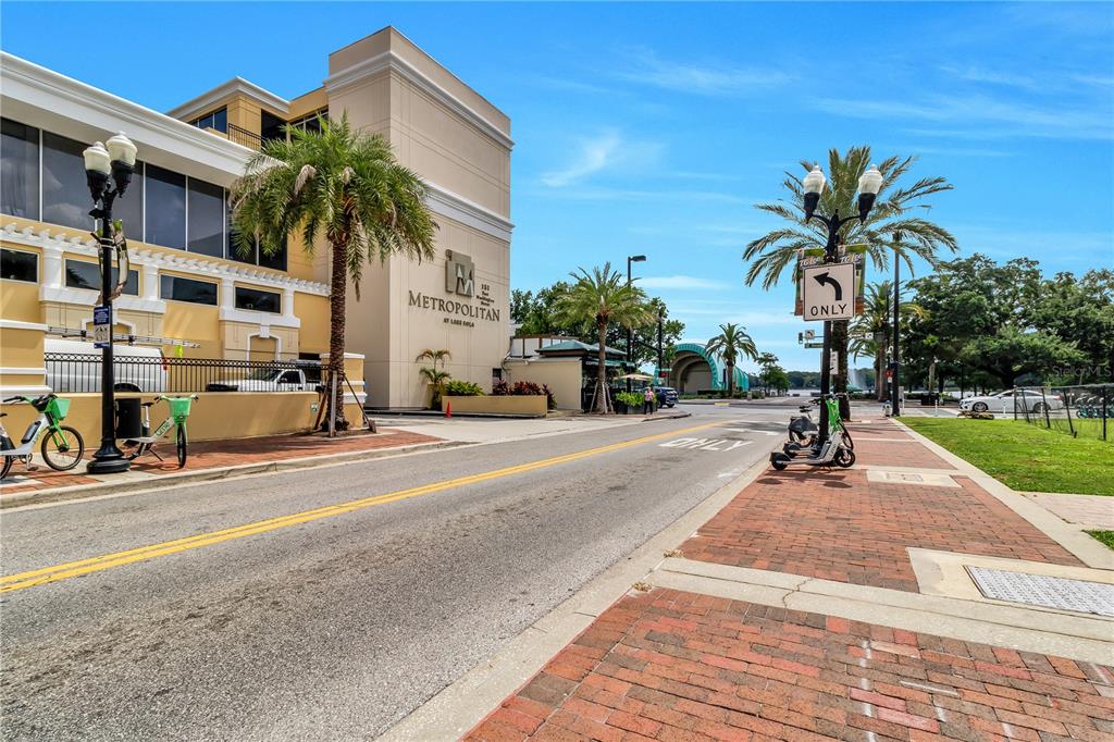 A street view showing the Metropolitan at Lake Eola building with palm trees and scooters — 151 E WASHINGTON STREET UNIT 5B, ORLANDO, FL