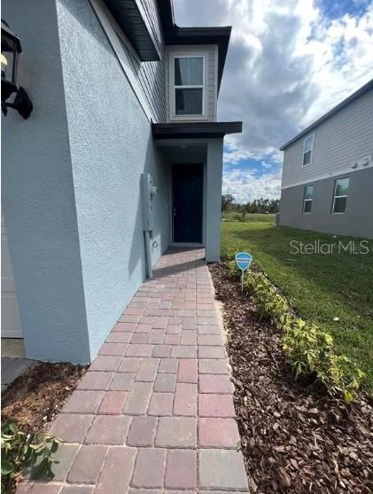 A paved walkway leads to the front entrance of a two-story blue stucco house — 756 LEGACY DR, DAVENPORT, FL