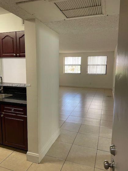 A view from an entryway looking into a kitchen with dark cabinets and a living area — DORAL, FL