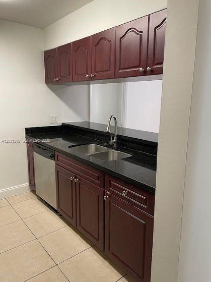 A kitchen features dark wood cabinets, black granite countertops, and a stainless steel dishwasher — DORAL, FL