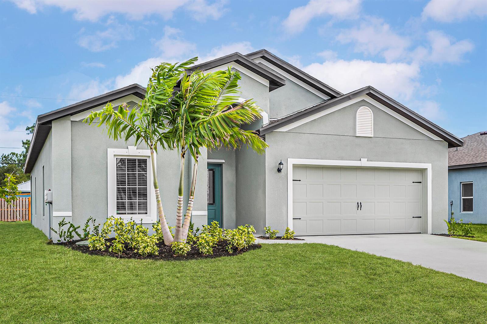 A single-story house with a gray stucco exterior, a two-car garage, and a palm tree — 5701 Palm Drive, Fort Pierce FL 34982, FORT PIERCE, FL
