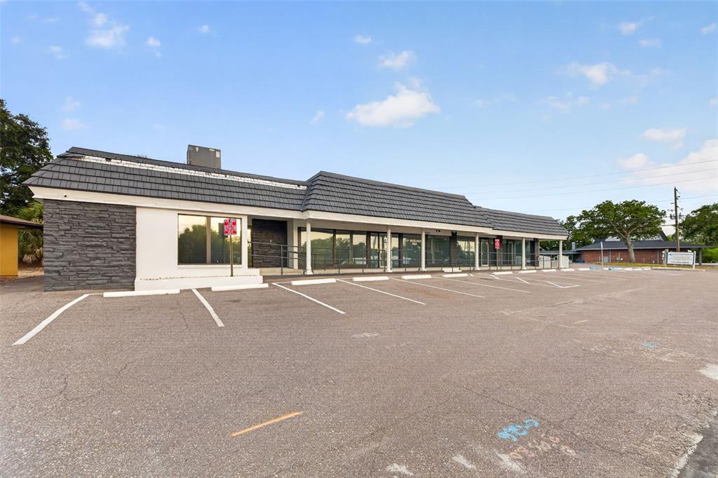 A single-story commercial building with a dark shingled roof and a paved parking lot — 1559 INDIAN ROCKS ROAD S, LARGO, FL