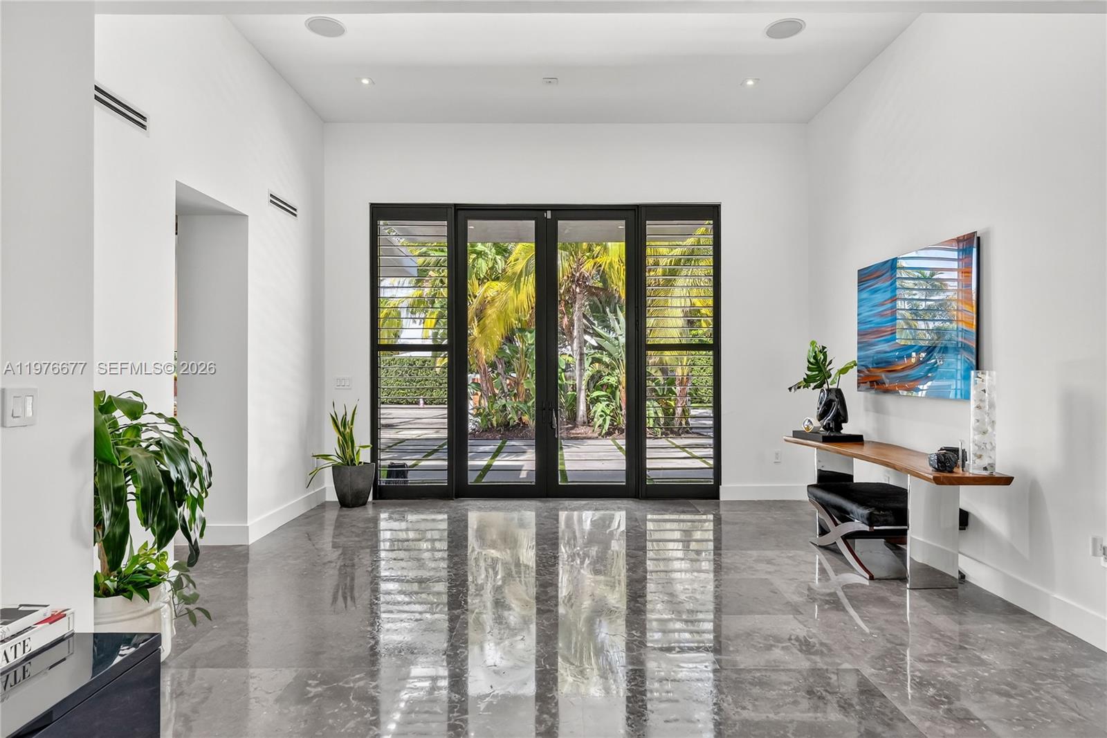 A bright entryway features polished gray marble floors, white walls, and black-framed glass doors — 1540 Cleveland Rd, Miami Beach FL 33141, MIAMI BEACH, FL