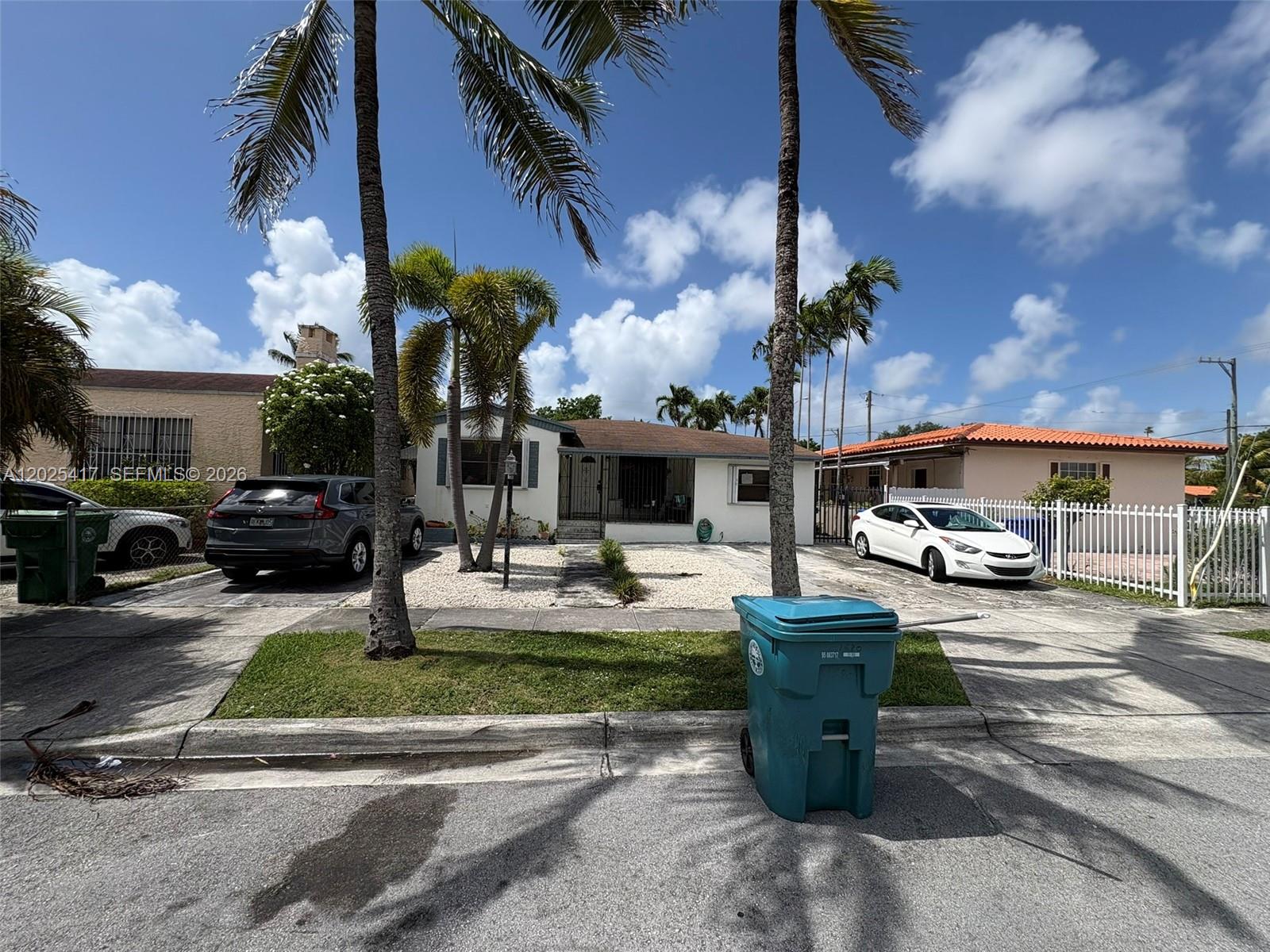 A single-story house with a gravel front yard, palm trees, and two parked cars — 1680 SW 14th Ter, Miami FL 33145, MIAMI, FL
