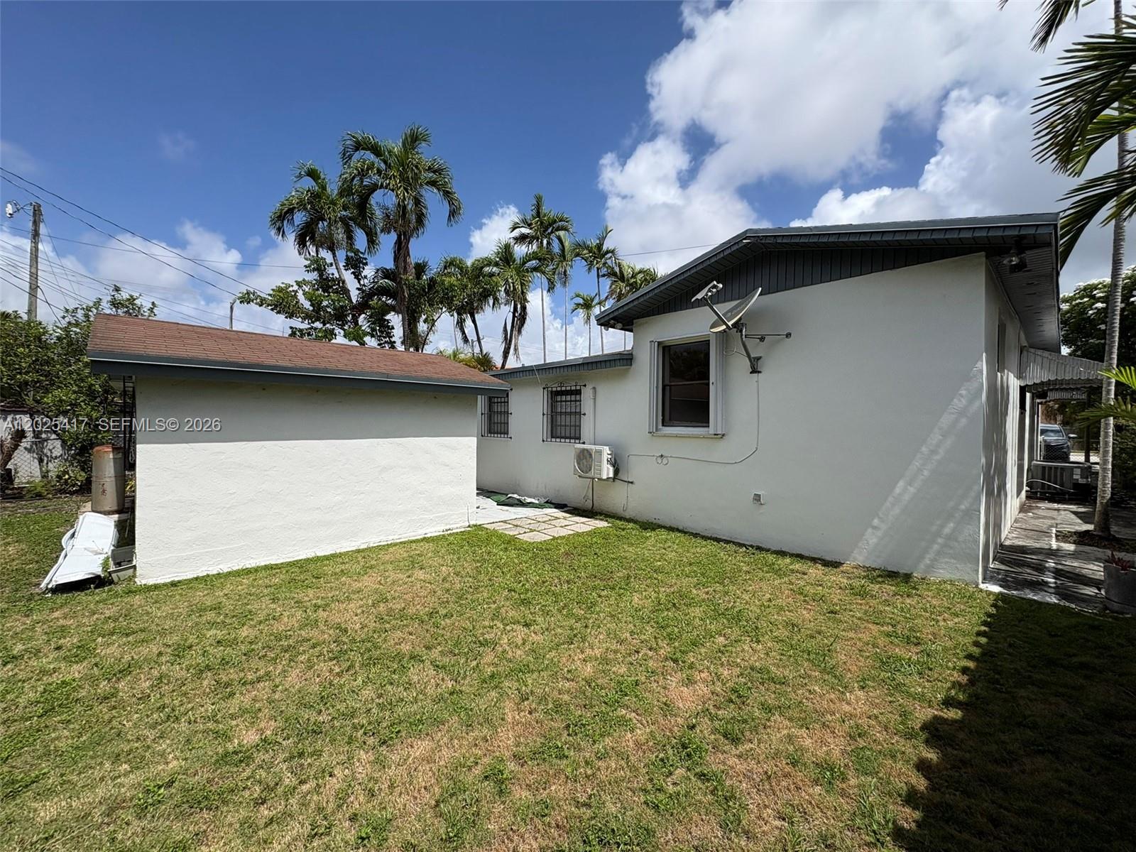 The exterior of a white house with a brown roof and a grassy backyard — 1680 SW 14th Ter, Miami FL 33145, MIAMI, FL