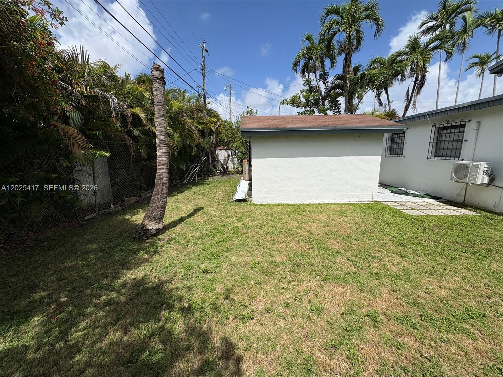 A grassy backyard features a small white shed, a palm tree, and a chain-link fence — 1680 SW 14th Ter, Miami FL 33145, MIAMI, FL