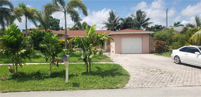 A single-story peach-colored house features a white garage door and a paved driveway — 98 Seminole Lane, Boca Raton FL 33487, BOCA RATON, FL