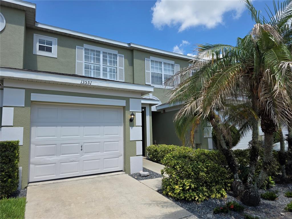 A row of two-story townhouses with attached garages and palm trees in the front yard — 13551 DANIELS LANDING CIRCLE, WINTER GARDEN, FL