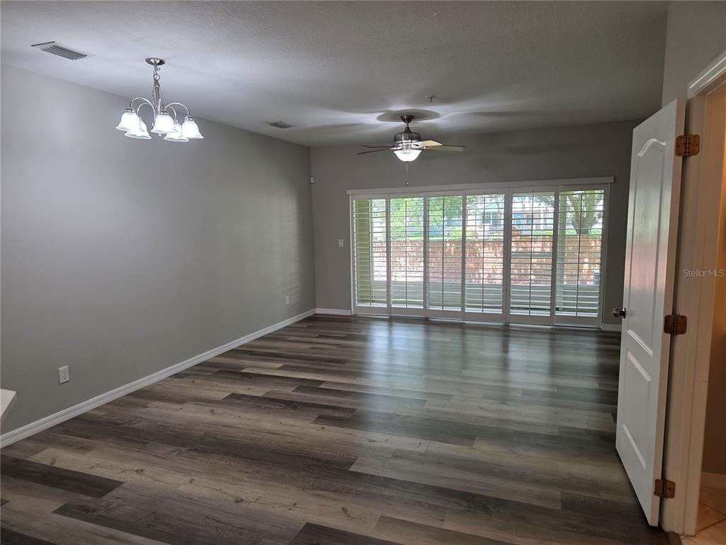 A row of green two-story townhomes with white garage doors and palm tree landscaping — 13551 DANIELS LANDING CIRCLE, WINTER GARDEN, FL