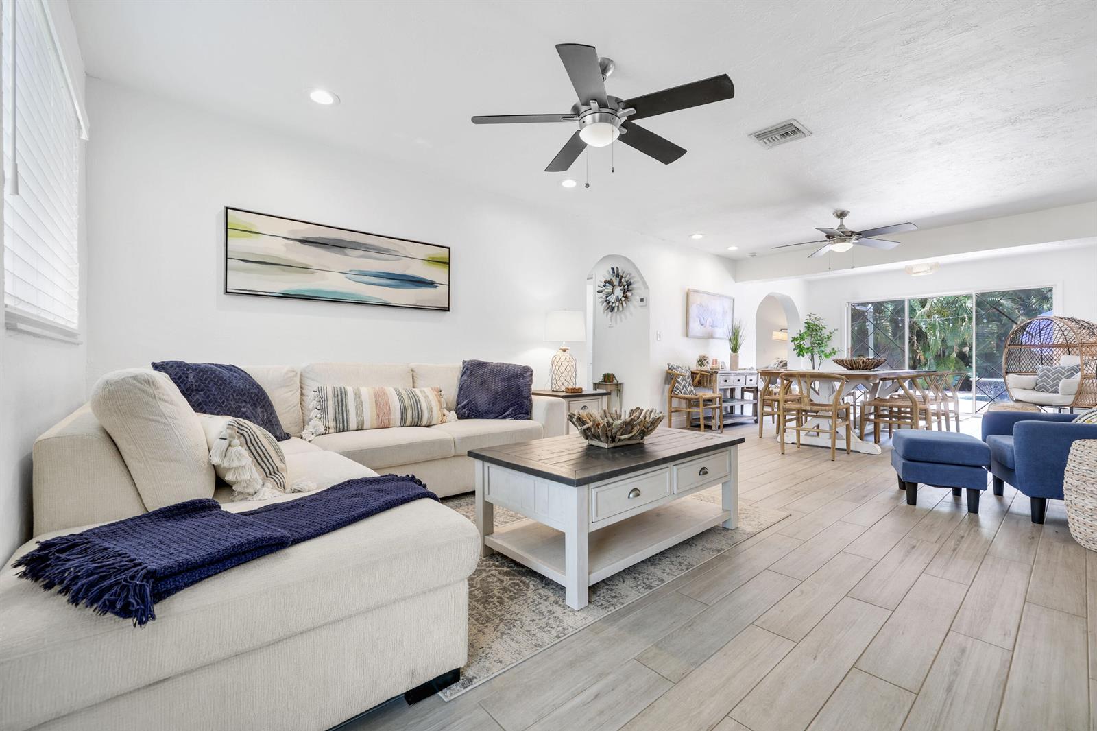 A bright, open-concept living and dining area features white walls, tile flooring, and ceiling fans — 342 SW 14th Street, Pompano Beach FL 33060, POMPANO BEACH, FL