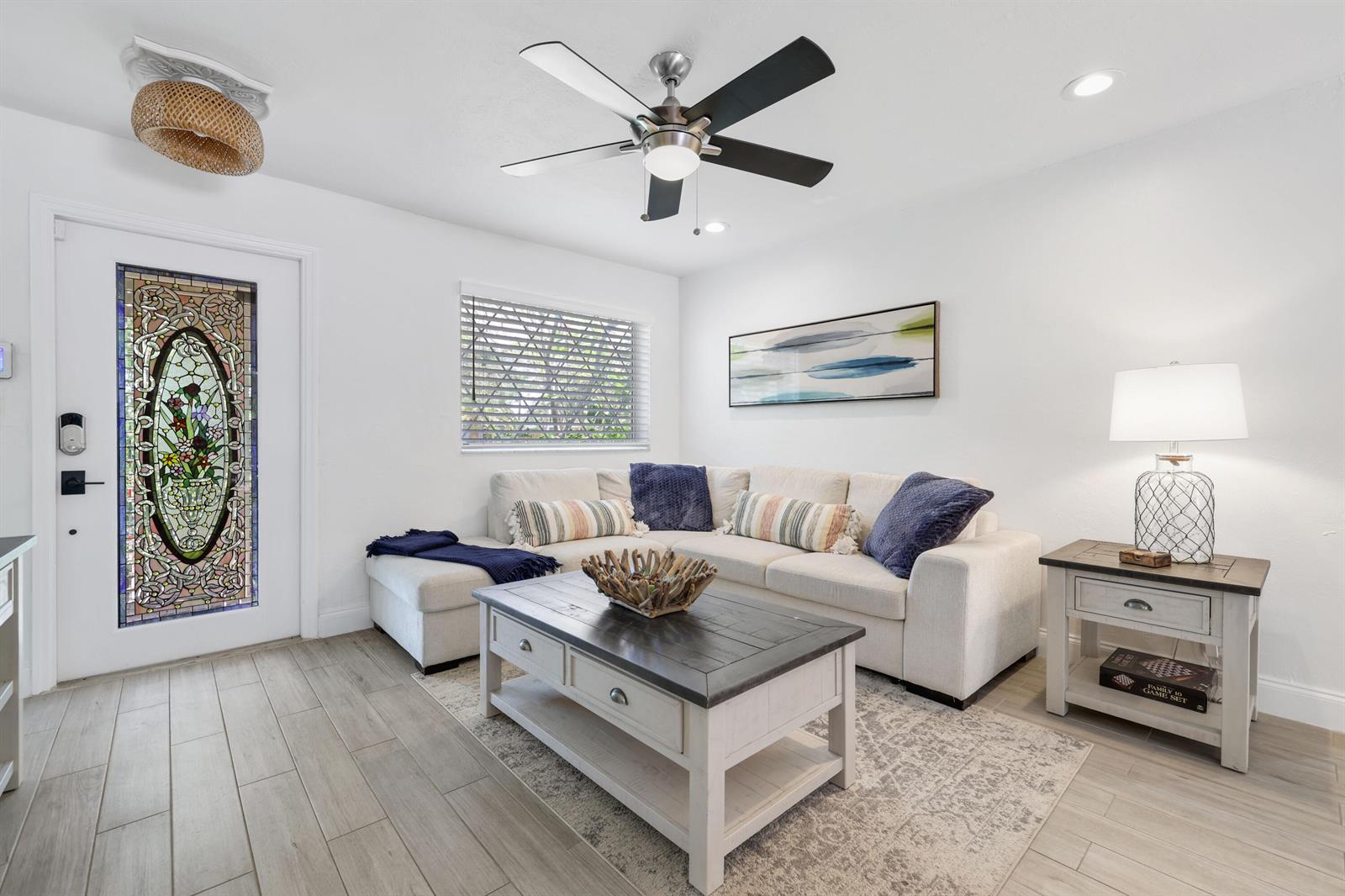 A living room features a sectional sofa, coffee table, stained glass door, and ceiling fan — 342 SW 14th Street, Pompano Beach FL 33060, POMPANO BEACH, FL