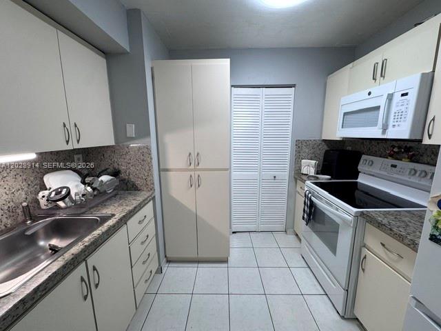 A kitchen features light-colored cabinets, granite countertops, a stainless steel sink, and white appliances — 11780 SW 18th St # 2, Miami FL 33175, MIAMI, FL