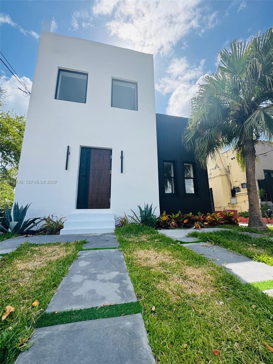 A modern two-story house features a white facade, a dark wood door, and black siding — 905 SW 13th Ct, Miami FL 33135, MIAMI, FL