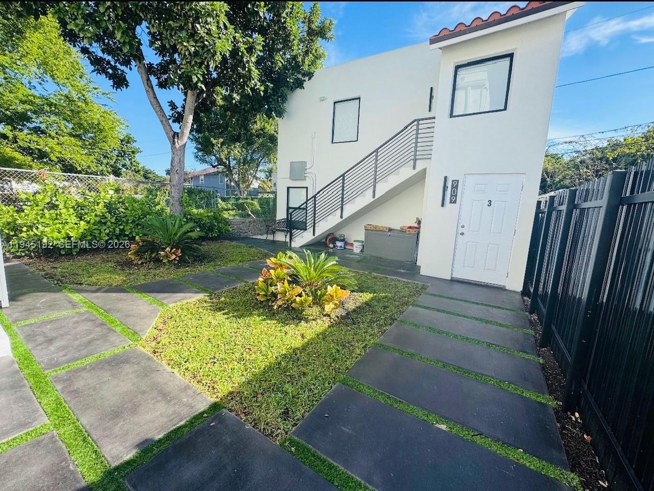 A two-story white building features an exterior staircase, a paved walkway, and a small lawn — 905 SW 13th Ct, Miami FL 33135, MIAMI, FL