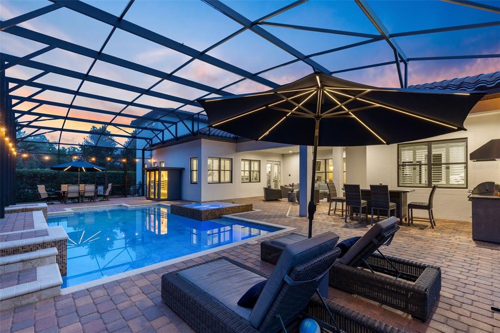 A screened-in patio features a swimming pool, hot tub, lounge chairs, and outdoor dining areas — 2218 SOARING EAGLE PLACE, LAKE MARY, FL