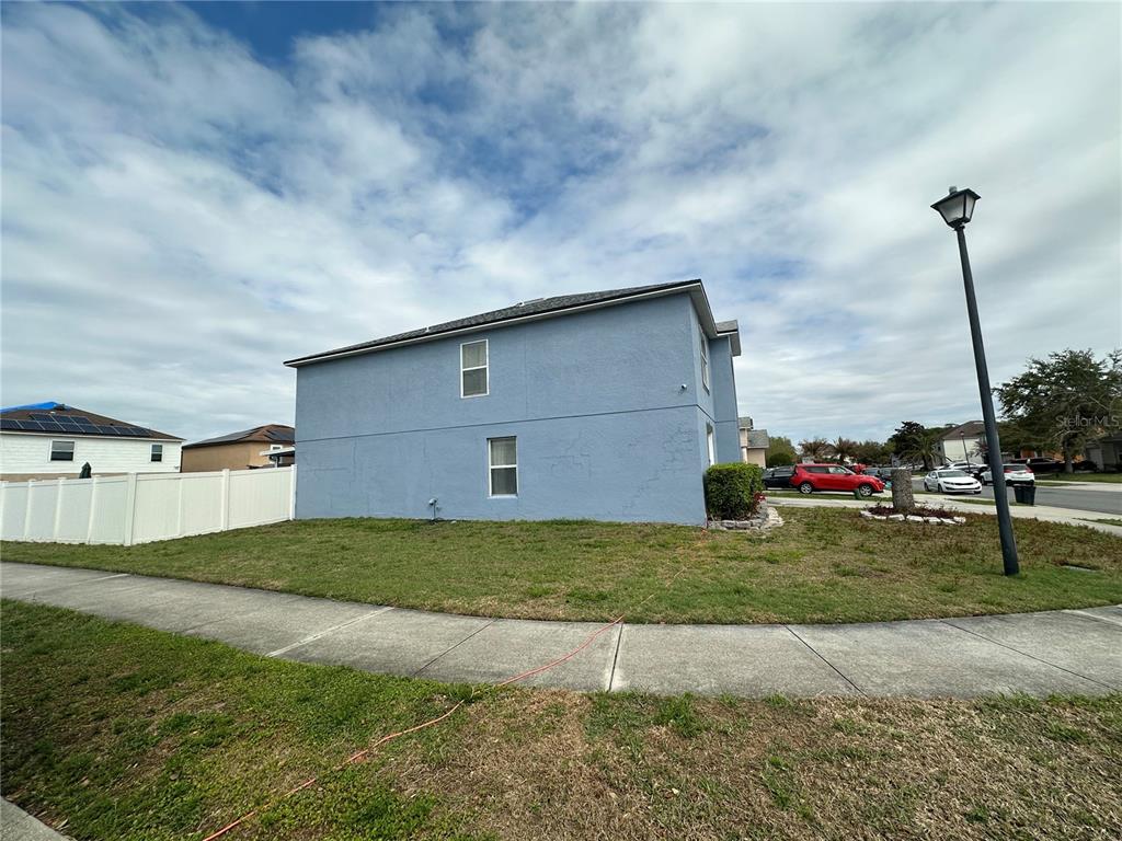 A two-story blue stucco house with two windows on the side wall — 102 WHEATFIELD CIRCLE, SANFORD, FL
