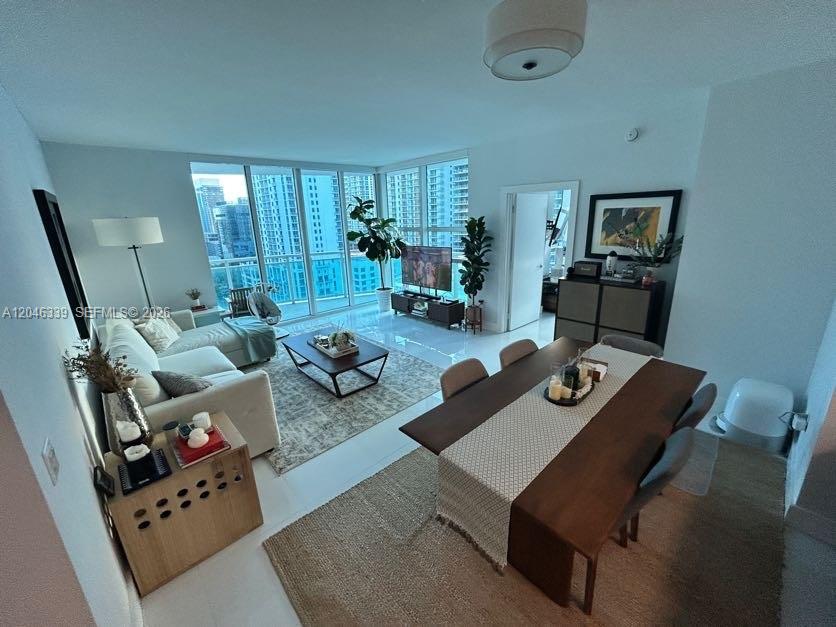 A modern living and dining area features floor-to-ceiling windows with city views — 951 Brickell Ave # 2011, Miami FL 33131, MIAMI, FL