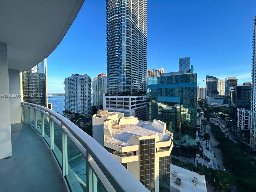 A balcony view overlooking a dense urban cityscape with multiple high-rise buildings and water — 951 Brickell Ave # 2011, Miami FL 33131, MIAMI, FL