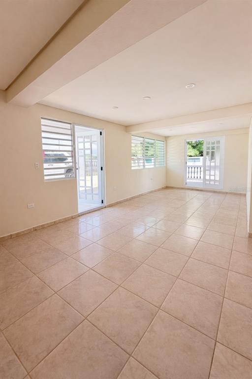 An empty room with light-colored tile flooring, recessed lighting, and two glass-paneled exterior doors — Carr 901 BARRIO CAMINO NUEVO, YABUCOA, PR
