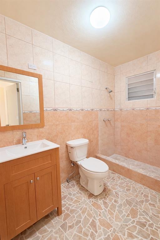 A bathroom with a wooden vanity, a toilet, and a tiled walk-in shower — Carr 901 BARRIO CAMINO NUEVO, YABUCOA, PR