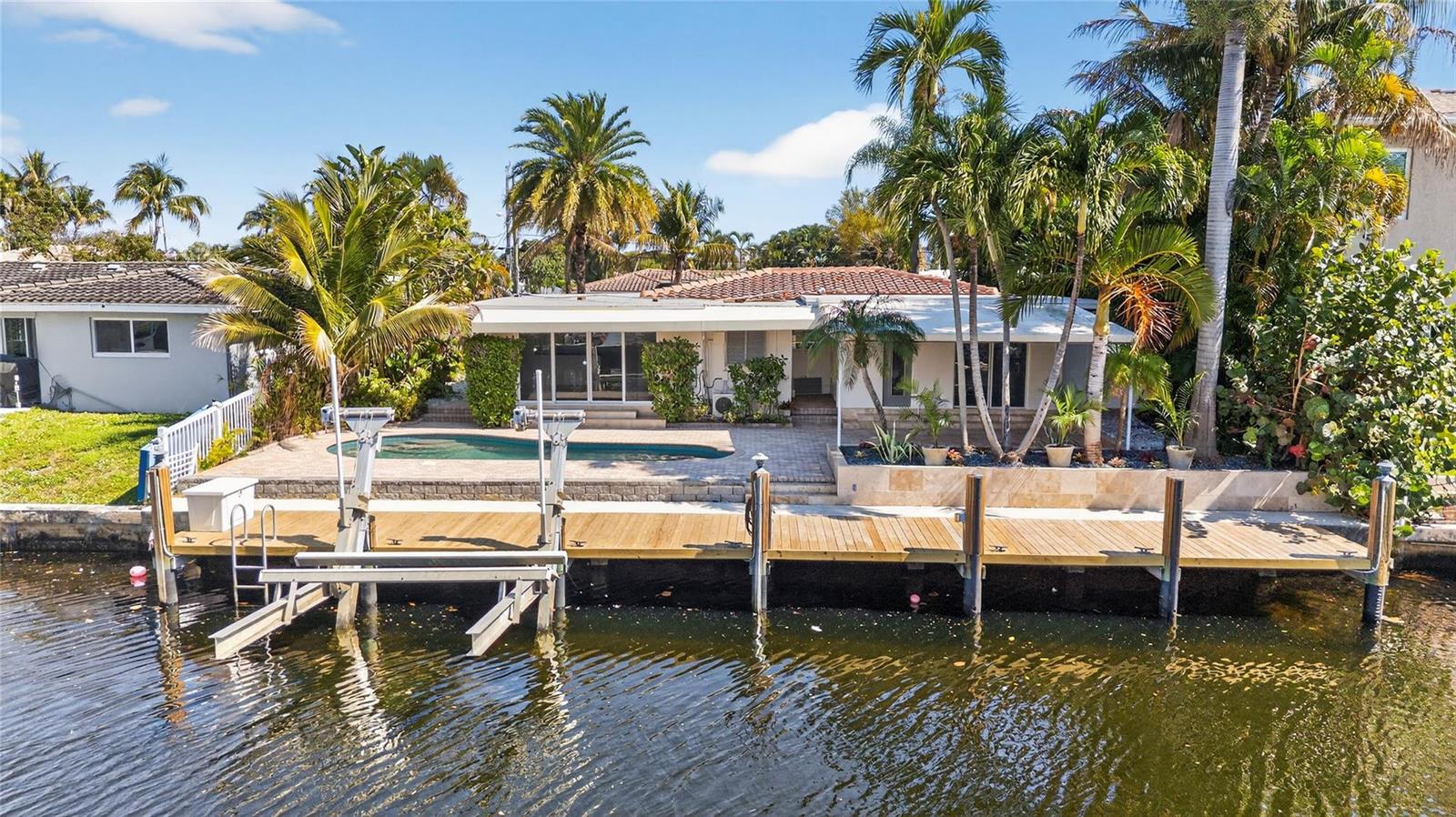 A waterfront house features a swimming pool, a wooden dock, and palm trees — 601 SE 5th Terrace, Pompano Beach FL 33060, POMPANO BEACH, FL