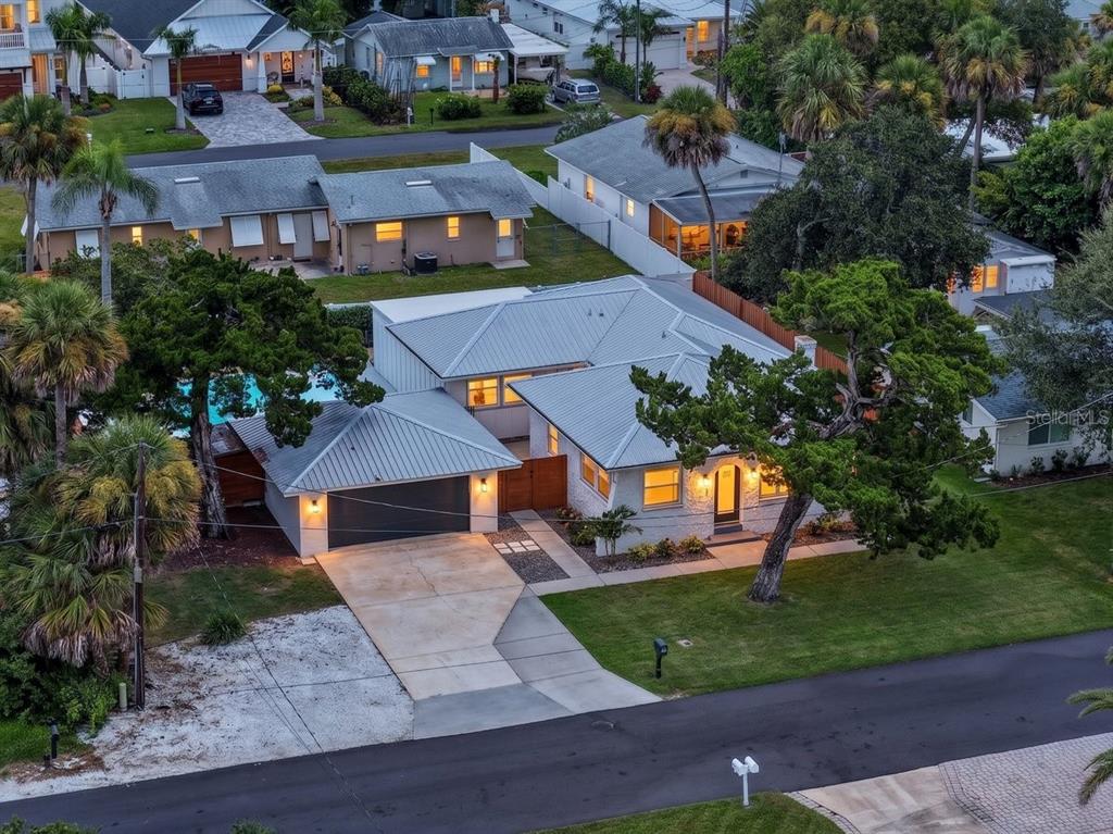 An aerial view of a white house with a metal roof, garage, and swimming pool — 507 GOODWIN AVENUE, NEW SMYRNA BEACH, FL