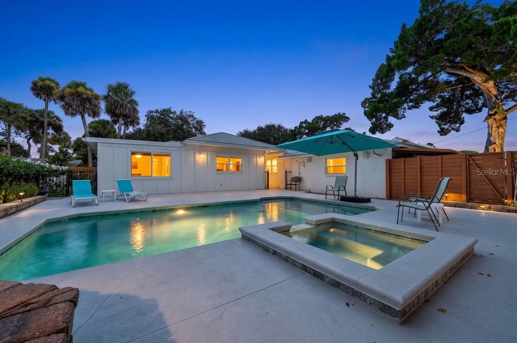 A backyard features a swimming pool, a raised spa, and a patio with lounge chairs — 507 GOODWIN AVENUE, NEW SMYRNA BEACH, FL
