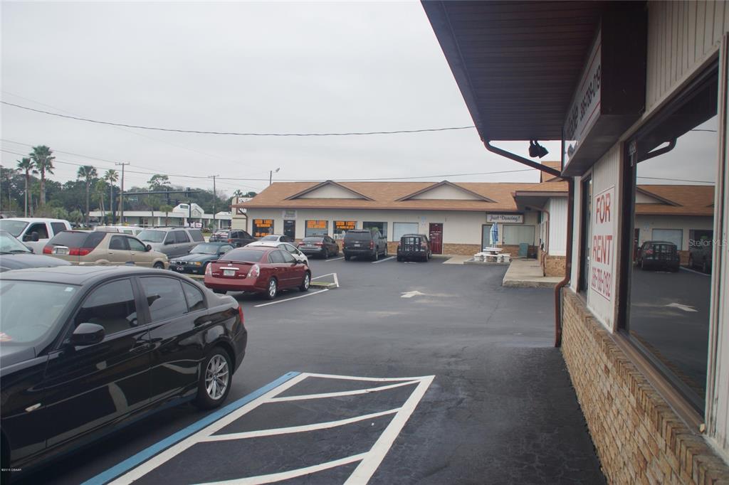 An exterior view of a commercial parking lot in front of a single-story retail building — 2355 S RIDGEWOOD AVENUE, SOUTH DAYTONA, FL