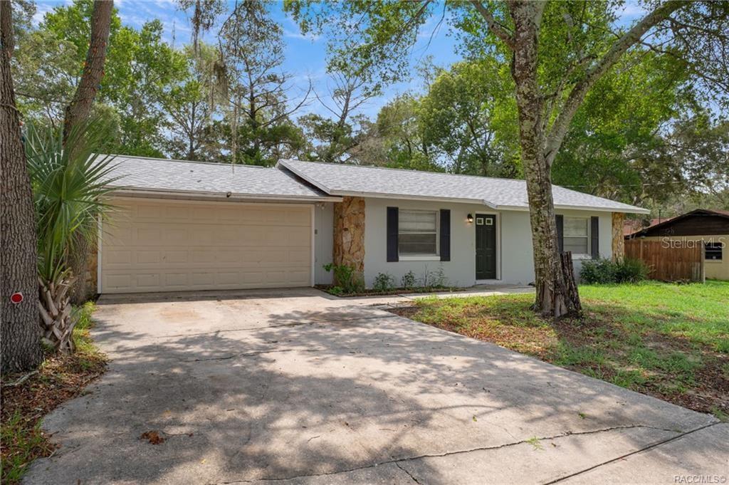 A single-story house with a light gray exterior, stone accents, and an attached two-car garage — 63 N CROFT AVENUE, INVERNESS, FL