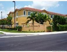 A tan multi-story apartment building with a sign reading Leeward stands behind a palm tree — 8243 NW 107th Path # 13, Doral FL 33178, DORAL, FL