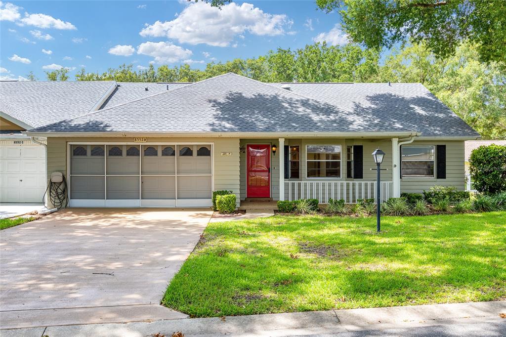A single-story house with light green siding, a red front door, and a gray roof — 8552 SW 92ND LANE UNIT D, OCALA, FL