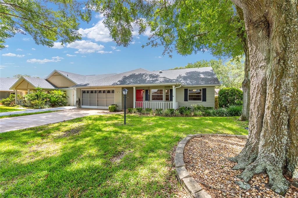 A single-story house with light green siding, a red front door, and a two-car garage — 8552 SW 92ND LANE UNIT D, OCALA, FL