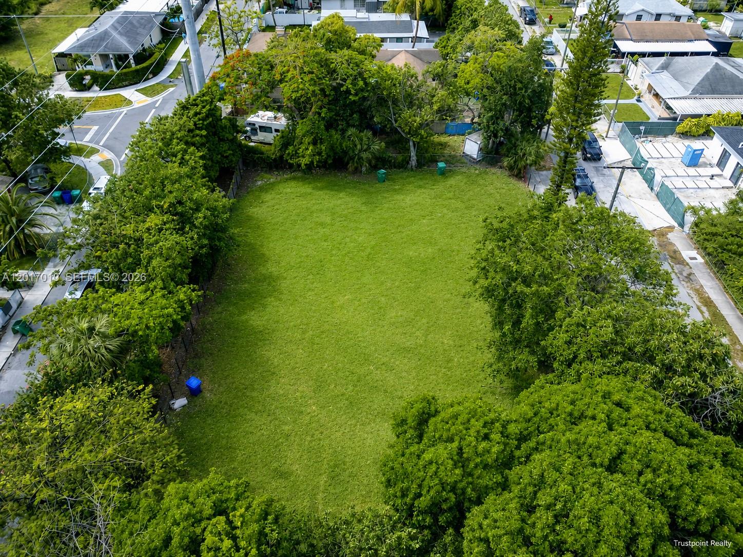 An aerial view shows a rectangular, grass-covered vacant lot surrounded by mature trees and houses — 3509 NW 9th Ave, Miami FL 33127, MIAMI, FL