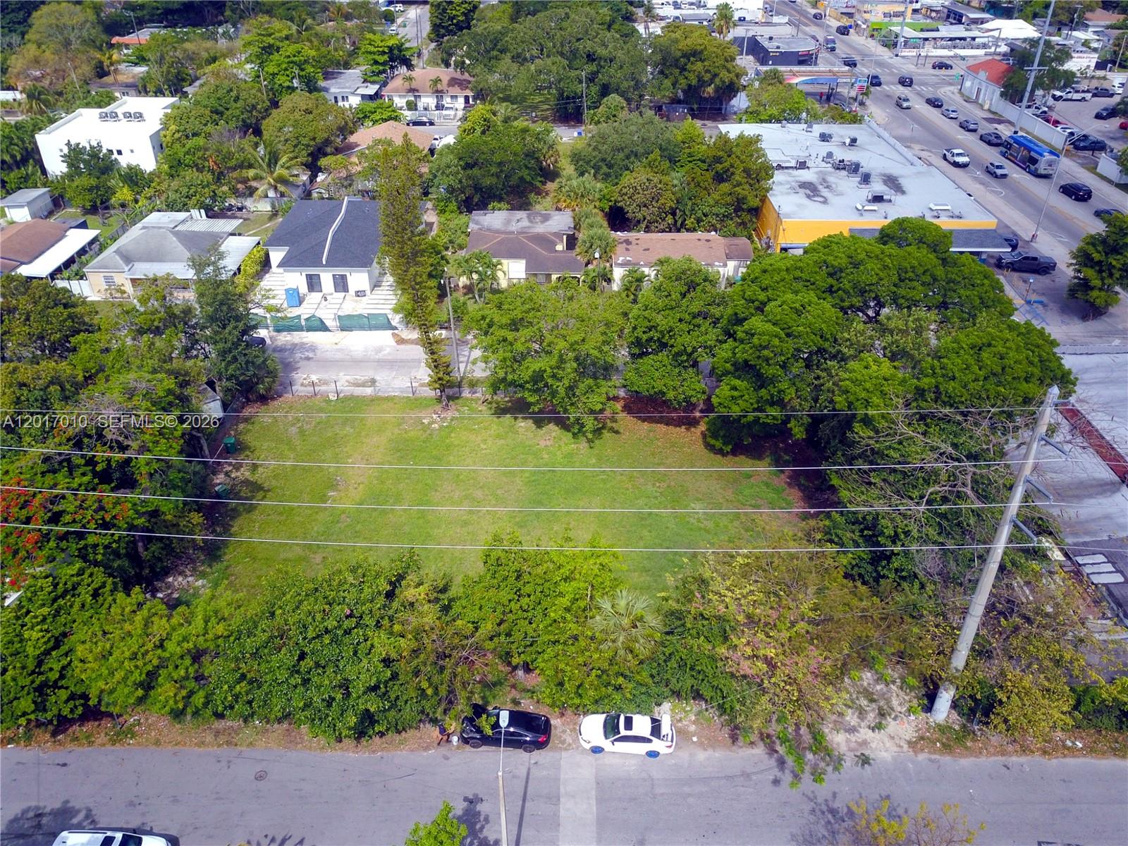 An aerial view shows a vacant grassy lot bordered by trees, houses, and a street — 3509 NW 9th Ave, Miami FL 33127, MIAMI, FL