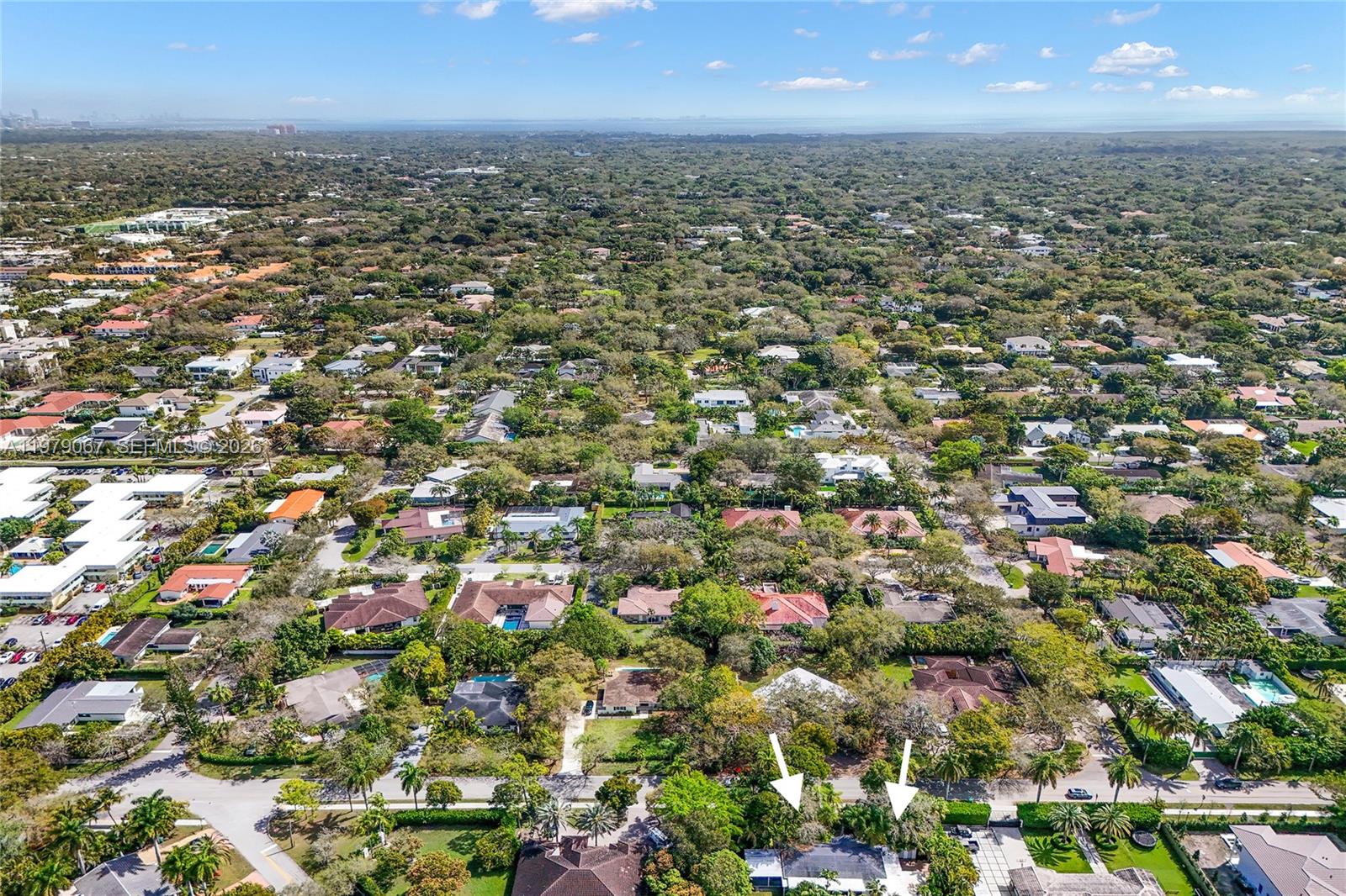 An aerial view shows a residential neighborhood with two white arrows pointing toward a house — 9330 SW 72nd Ave, Pinecrest FL 33156, PINECREST, FL