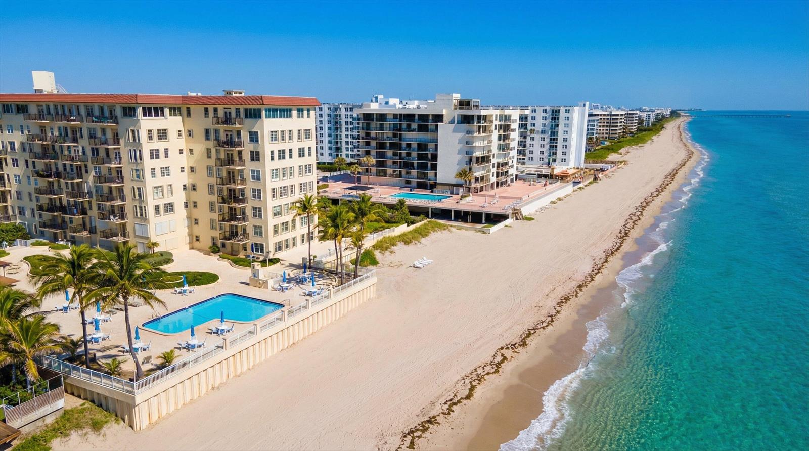 An aerial view of beachfront condominium buildings with swimming pools and a sandy coastline — 3475 S Ocean Boulevard # 715, Palm Beach FL 33480, PALM BEACH, FL