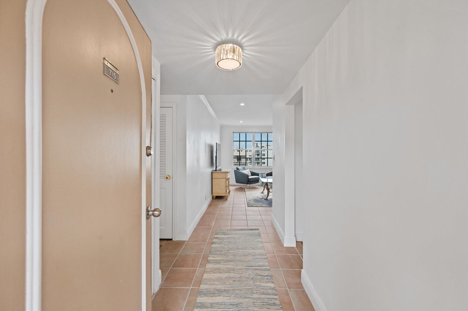 An entryway leads through a tiled hallway into a living area with a large window — 3475 S Ocean Boulevard # 715, Palm Beach FL 33480, PALM BEACH, FL