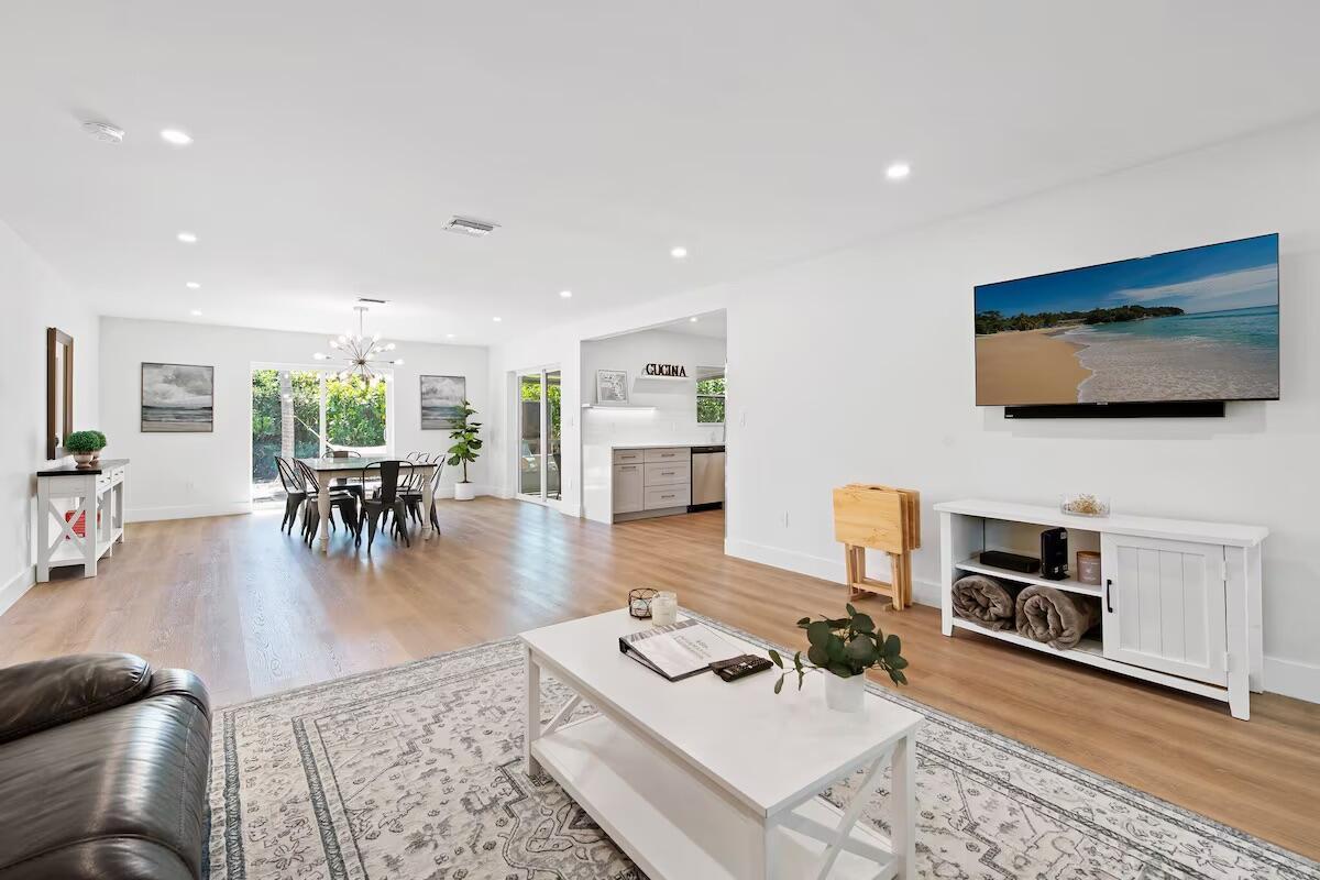 A bright, open-concept living and dining area features white walls, light wood floors, and furniture — 486 NE 29th Street, Boca Raton FL 33431, BOCA RATON, FL