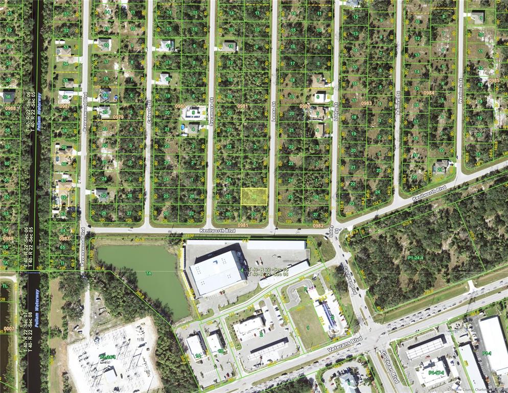 This is an aerial map showing residential lots and commercial buildings near a waterway — 493 LEONA STREET, PORT CHARLOTTE, FL