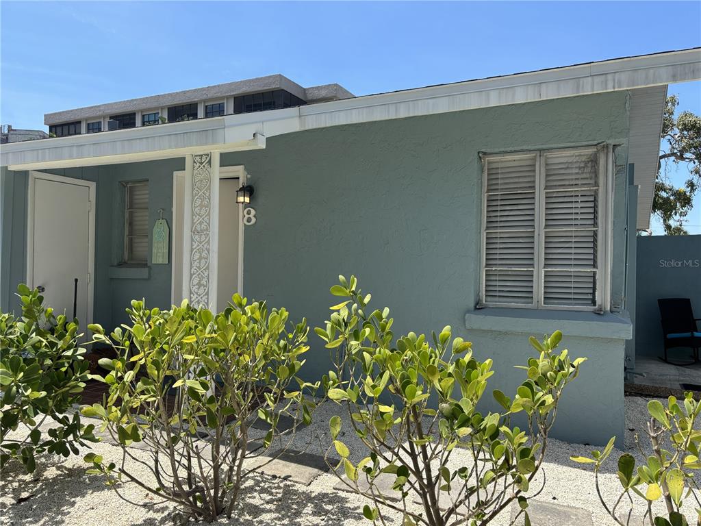 A light blue exterior wall features a window with shutters and a front door — 170 ROOSEVELT DRIVE UNIT 8, SARASOTA, FL