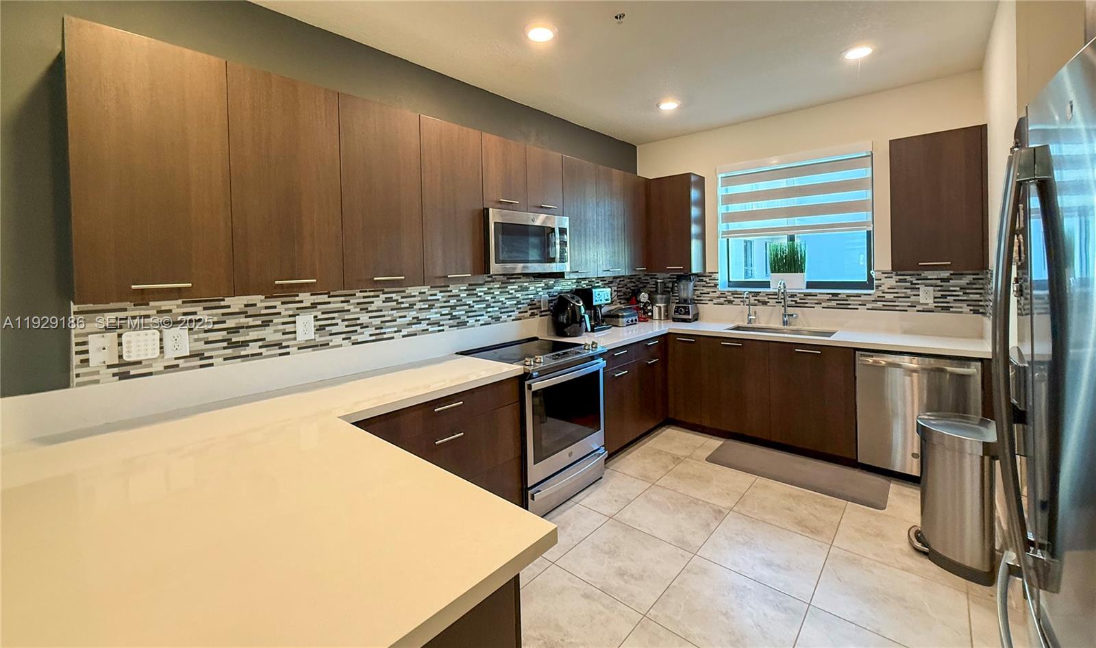 A kitchen features dark wood cabinets, stainless steel appliances, and white countertops — 4654 NW 84th Ave, Doral FL 33166, DORAL, FL