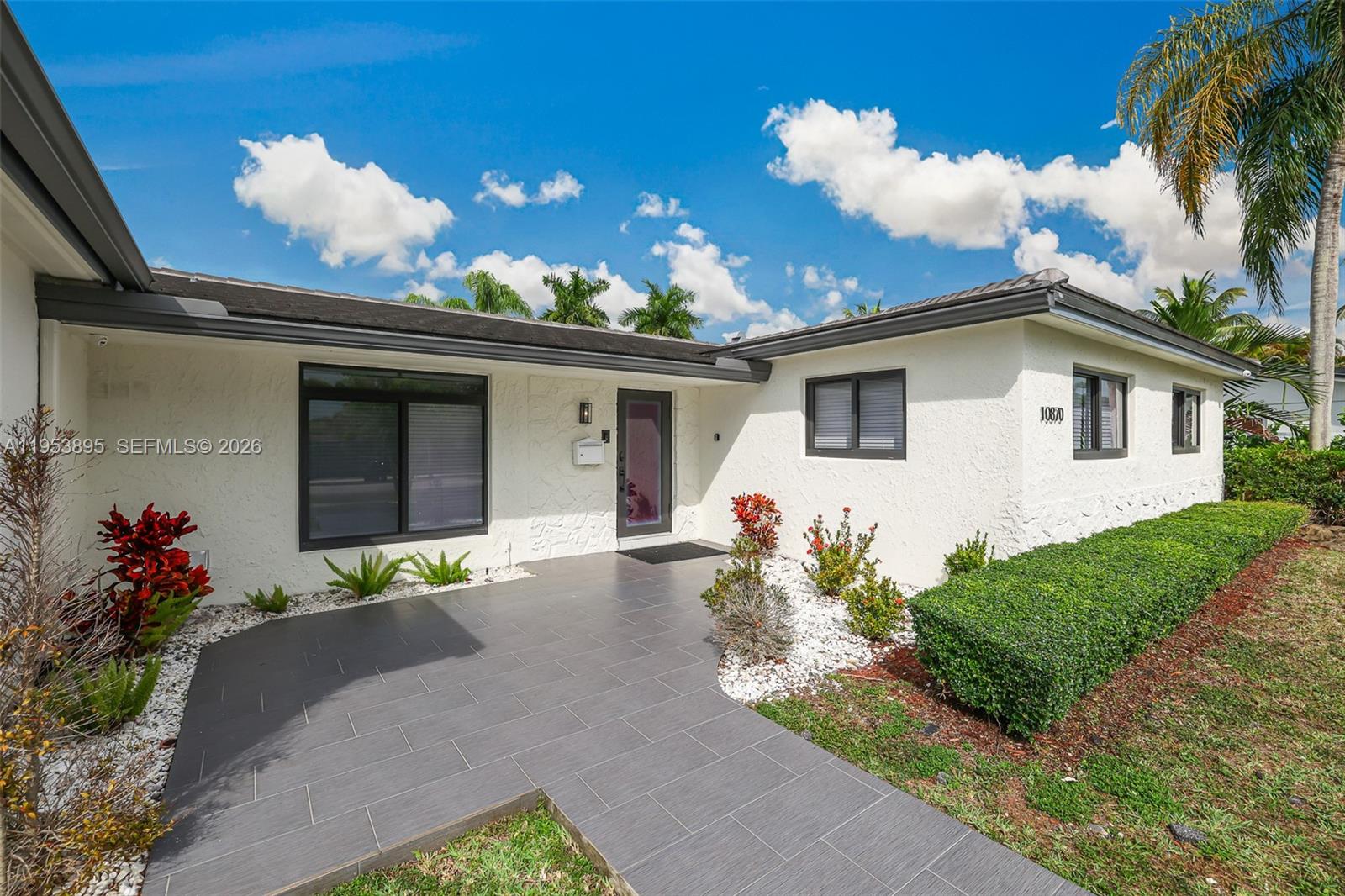 The exterior of a white house features a gray tiled walkway and a front entrance — 10870 SW 106th Ave, Miami FL 33176, MIAMI, FL