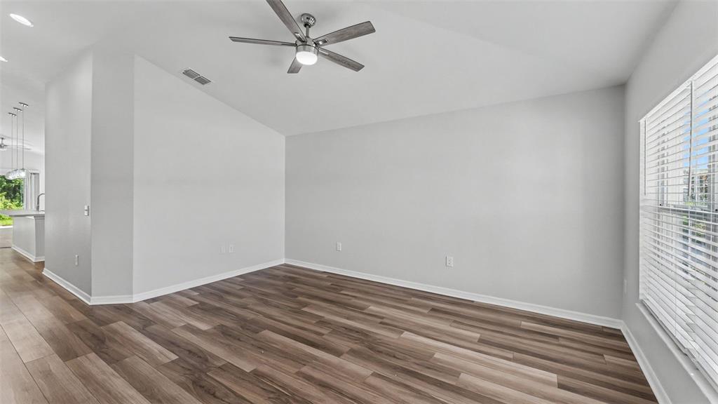 An empty room with light gray walls, wood-look flooring, a ceiling fan, and white blinds — 1268 PINTAIL PLACE, LAKELAND, FL