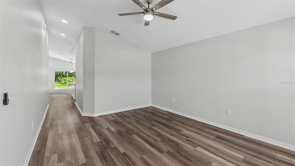 An empty room with light gray walls, wood-look flooring, and a ceiling fan — 1268 PINTAIL PLACE, LAKELAND, FL