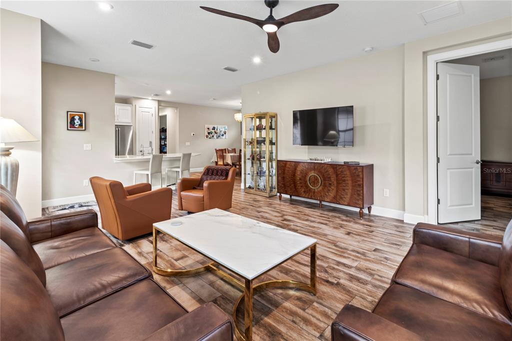 A living room features leather furniture, a marble coffee table, and wood-look tile flooring — 14655 DERNA TERRACE, BRADENTON, FL