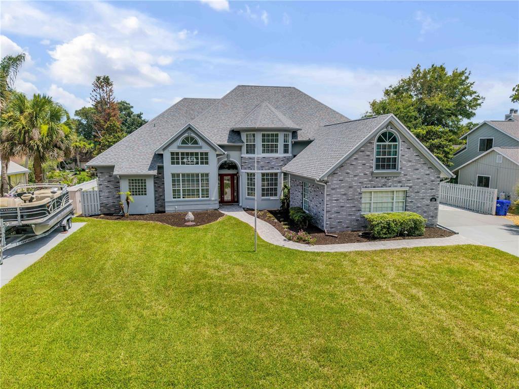 A gray brick house with a front lawn and an inset photo of a pool — 128 GODFREY ROAD, EDGEWATER, FL